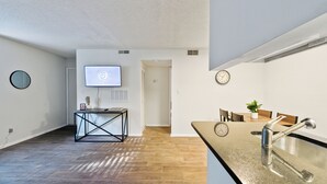 A modern kitchen with a granite countertop, stainless steel sink, and a dining area with a wooden table and chairs. - Northcliffe 404 I Fully Furnished 1 Bedroom 1 Ba (Winston-Salem)
