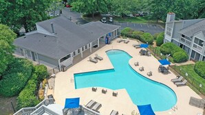 An aerial view of a hotel with a large swimming pool, lounge chairs, and a covered patio area. - Northcliffe 404 I Fully Furnished 1 Bedroom 1 Ba (Winston-Salem)