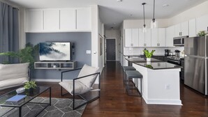 A modern kitchen with white cabinets, stainless steel appliances, and a central island. - Spacious 2BD With Private Balcony and Free Parking 2 (Charlotte)