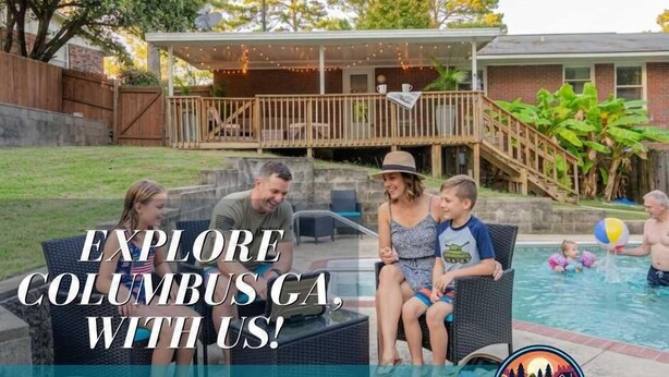 Une famille près d’une piscine, avec un patio couvert et une maison en briques en arrière-plan.