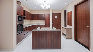 Una cocina moderna con alacenas de madera oscura, una isla central y un horno empotrado.