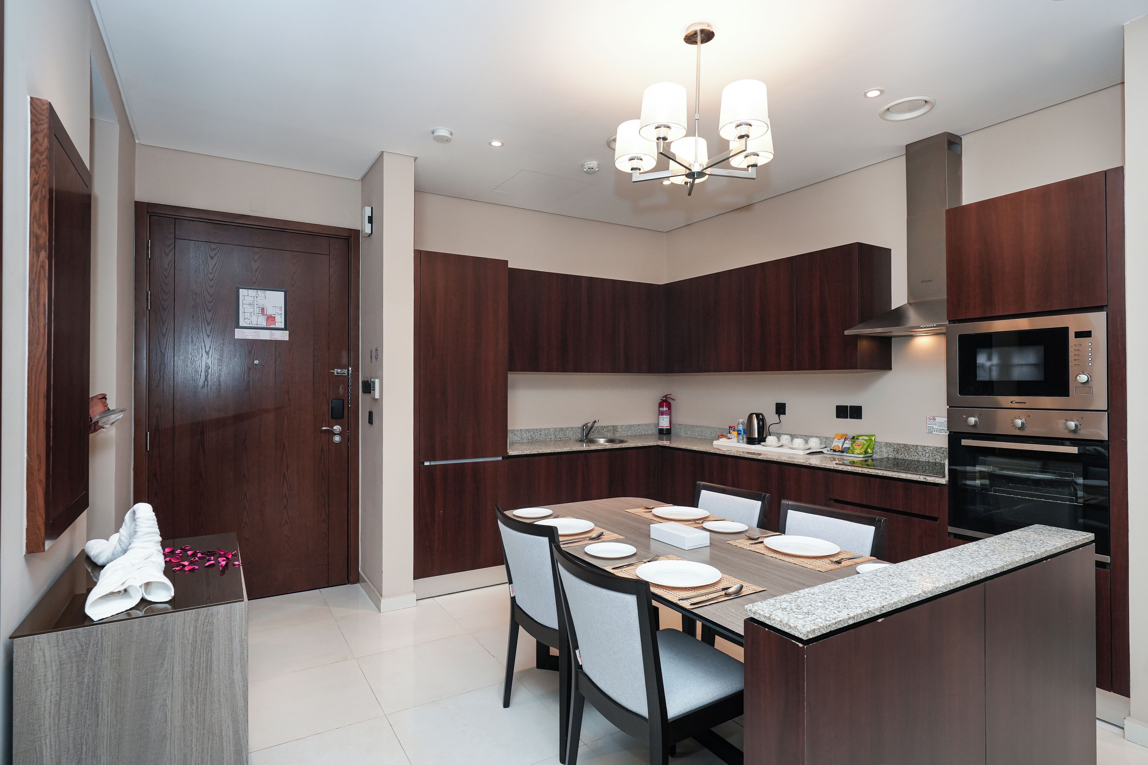 A modern kitchen with dark wood cabinets, a built-in microwave, and a granite countertop.