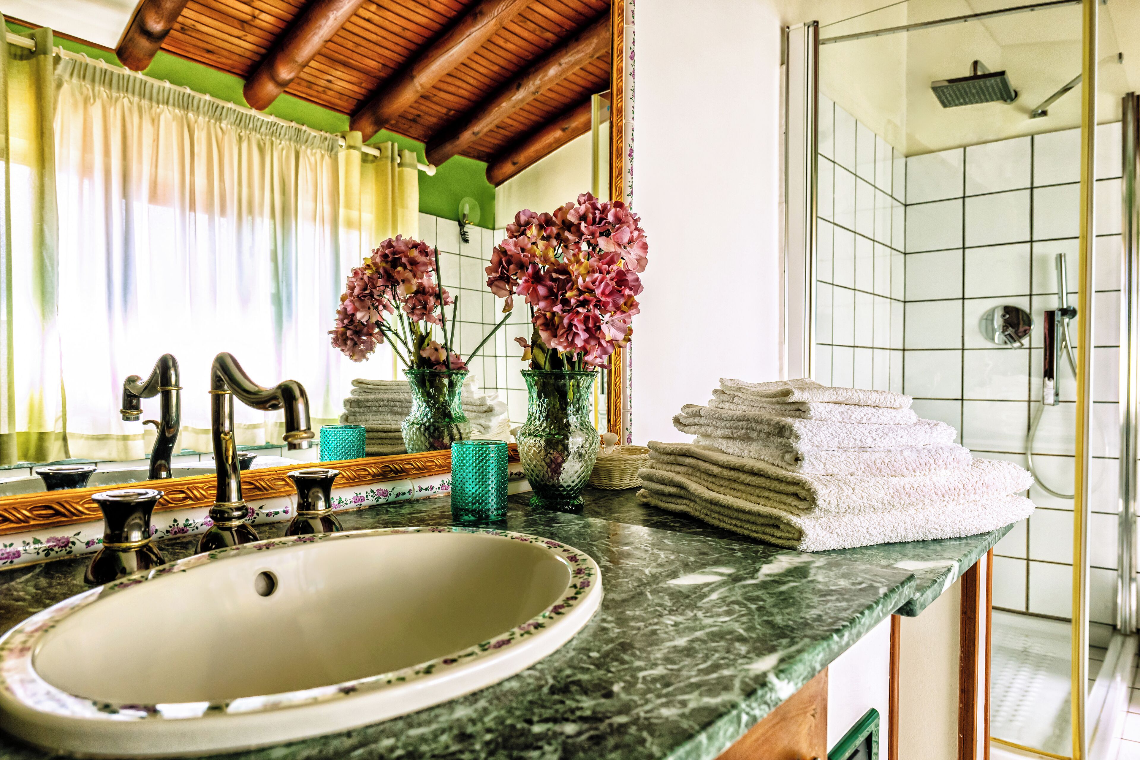 A bathroom with a sink, mirror, and shower.