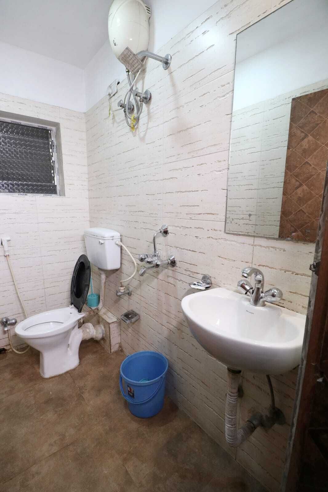 A bathroom with a toilet, bidet, sink, and a mirror.