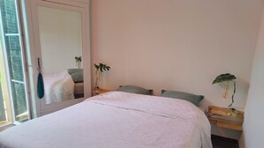 A bedroom with a bed, a mirror, two bedside tables, and a potted plant. - Apartment 44 m2. Type 2 (Aix-en-Provence)