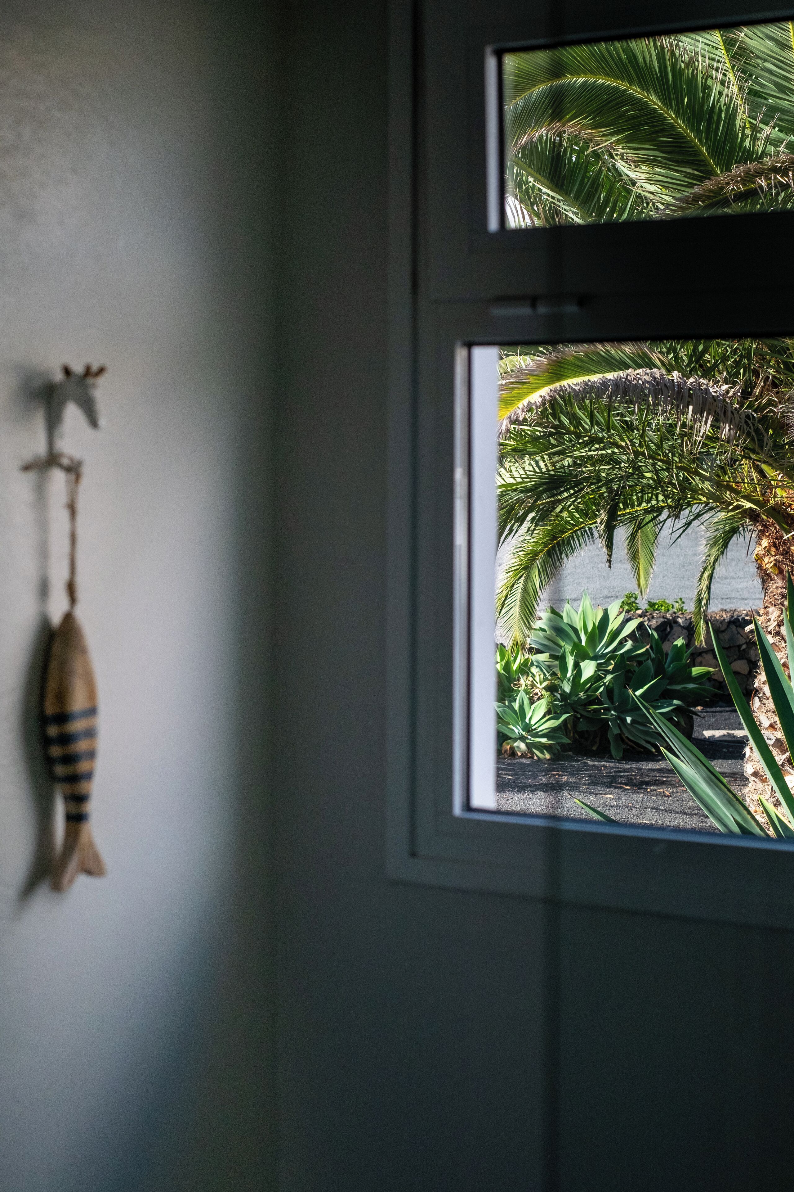 A room with a window overlooking a garden.