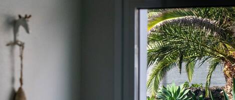 A room with a window overlooking a garden.