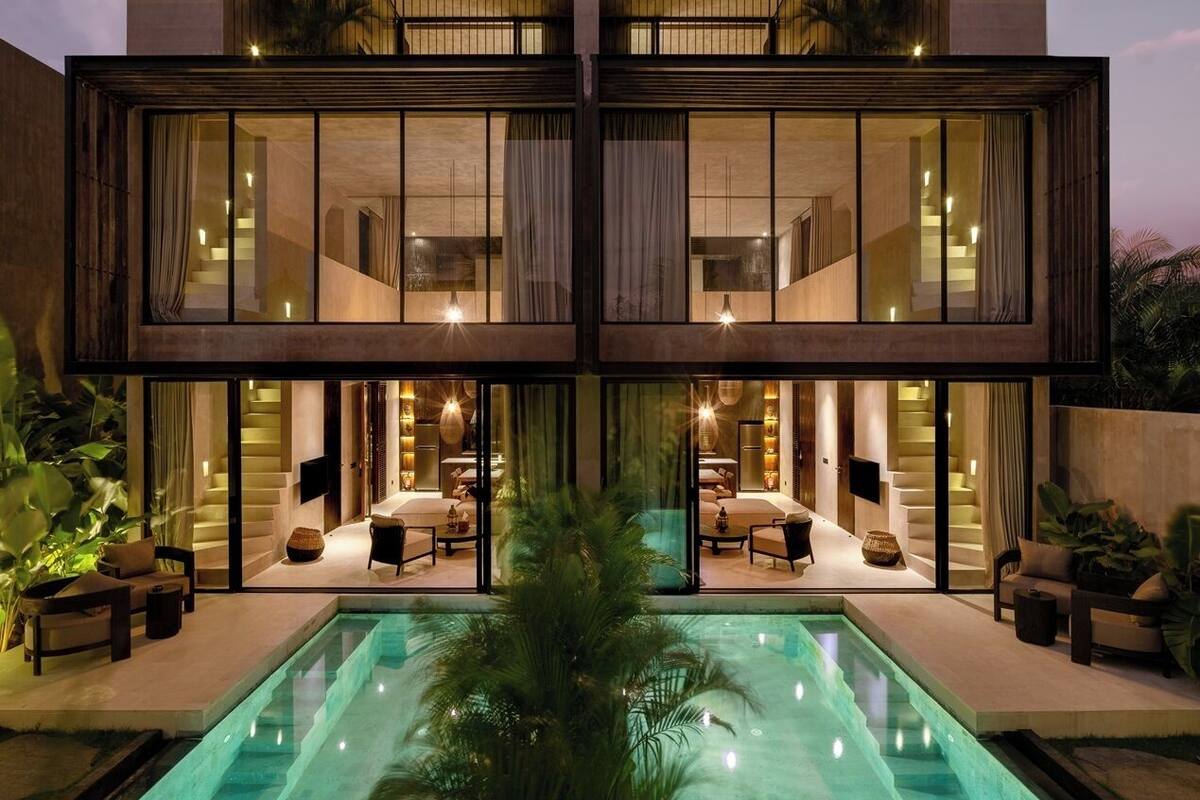 A modern two-story house with a swimming pool, large windows, and outdoor seating areas.