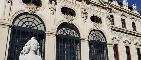Um edifício imponente com esculturas elaboradas e um grande arco central.
