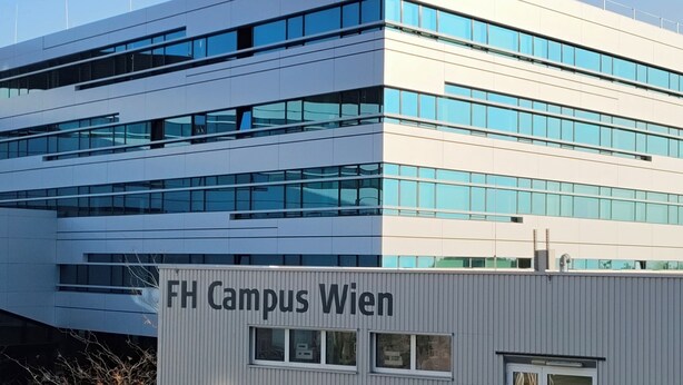 Een modern gebouw met een bord waarop 