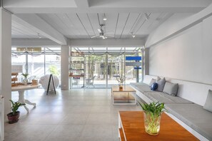 Un interior moderno con sofá, mesa de centro y plantas en macetas.