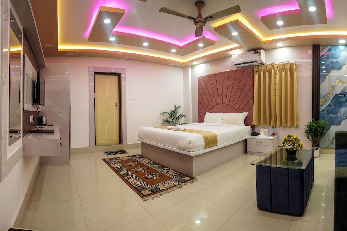 A modern bedroom with a bed, bedside table, nightstand, and a decorative wall piece.