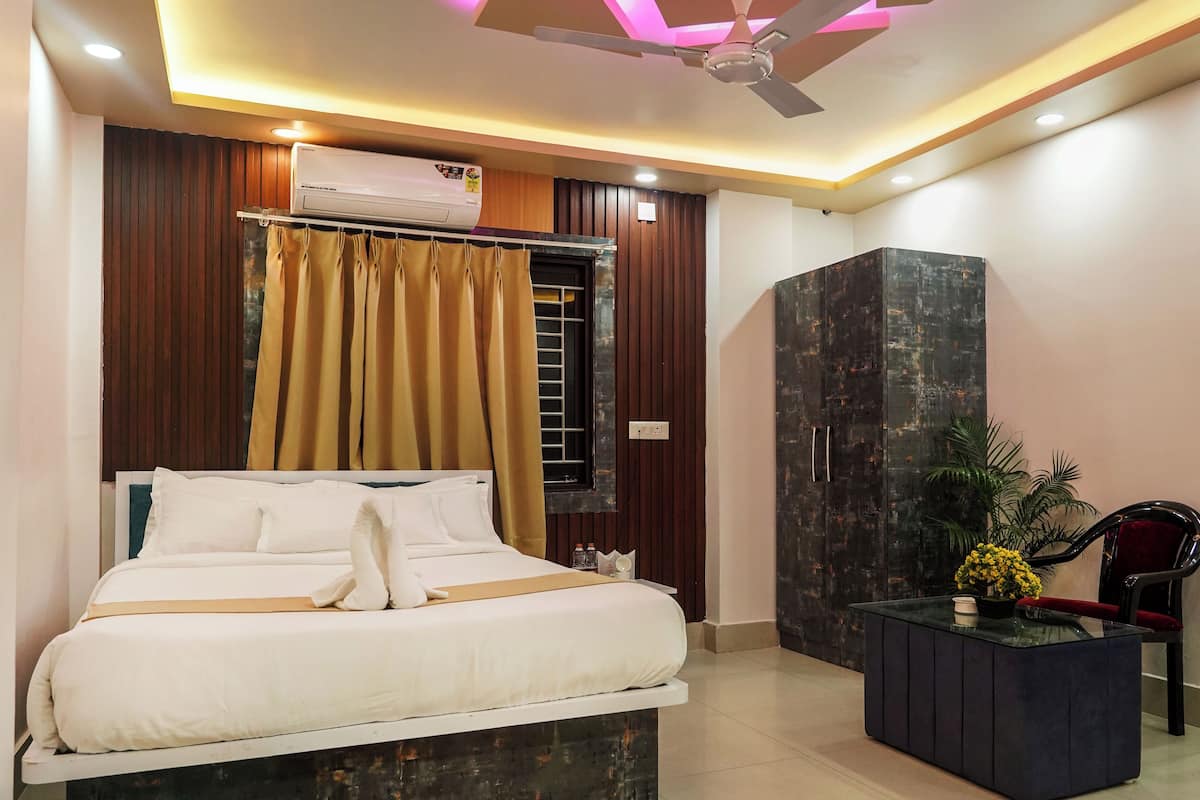 A modern bedroom with a bed, a ceiling fan, and a dark-toned wardrobe.