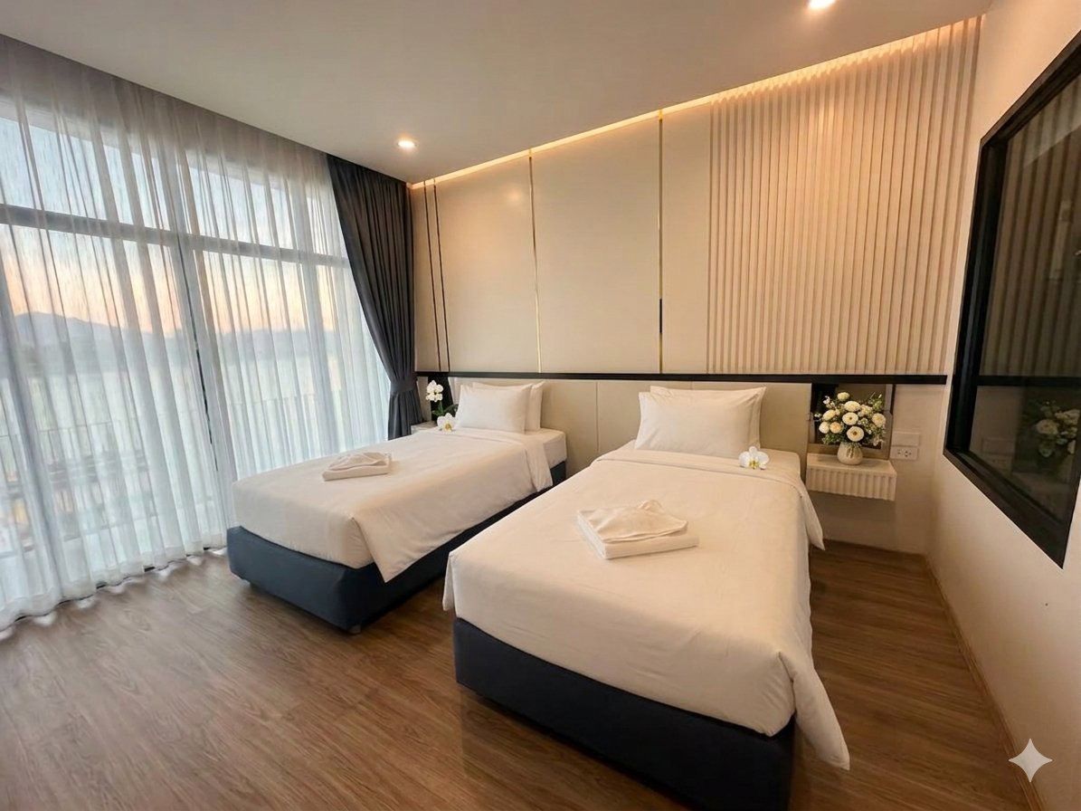 A hotel room with two beds, a large window with sheer curtains, a bedside table with a vase of flowers, and a view of the cityscape.