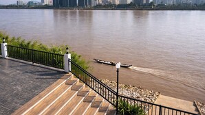 A riverside walkway with a view of a city skyline in the background. - View khong Hotel (Chiang Saen)