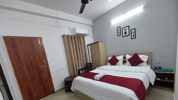 Une chambre d’hôtel équipée d’un lit, d’une armoire, d’un miroir, d’un bureau et d’un distributeur d’eau.