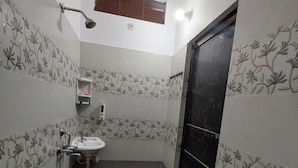 Une petite salle de bain comprenant des toilettes, un lavabo et une douche.