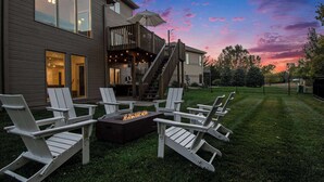 Una casa moderna con terraza, mobiliario exterior y una chimenea.