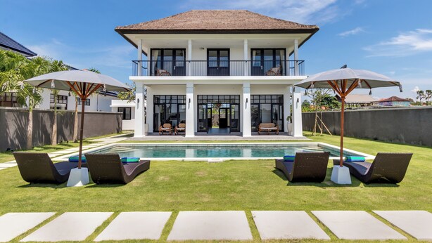 A two-story house with a swimming pool, lounge chairs, and umbrellas. - Villa Sakayana (Canggu)
