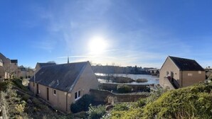 Aussicht auf einen Fluss mit Gebäuden, einer Brücke und blauem Himmel.