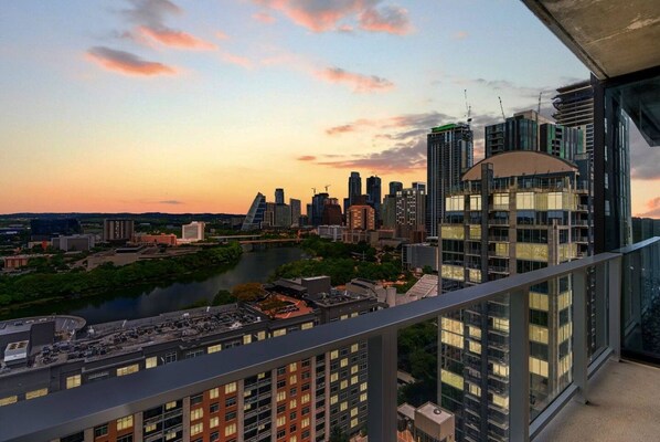 A high-rise building with a view of a city skyline and a river.