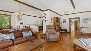 A spacious living room with a leather sofa, a recliner, and a wooden coffee table. - !!Duck Pond Charming 3bed 2 bath house!! (Gainesville)