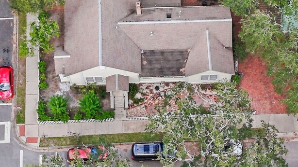 An aerial view of a two-story house with a central garage, a driveway, and a small front yard with trees and shrubs. - !!Duck Pond Charming 3bed 2 bath house!! (Gainesville)