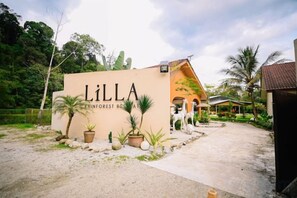 A building with a sign reading 'LILLA INNFOREST RESORT' surrounded by potted plants and palm trees. - Lilla Rainforest Retreat @ Hulu Langat (Hulu Langat)