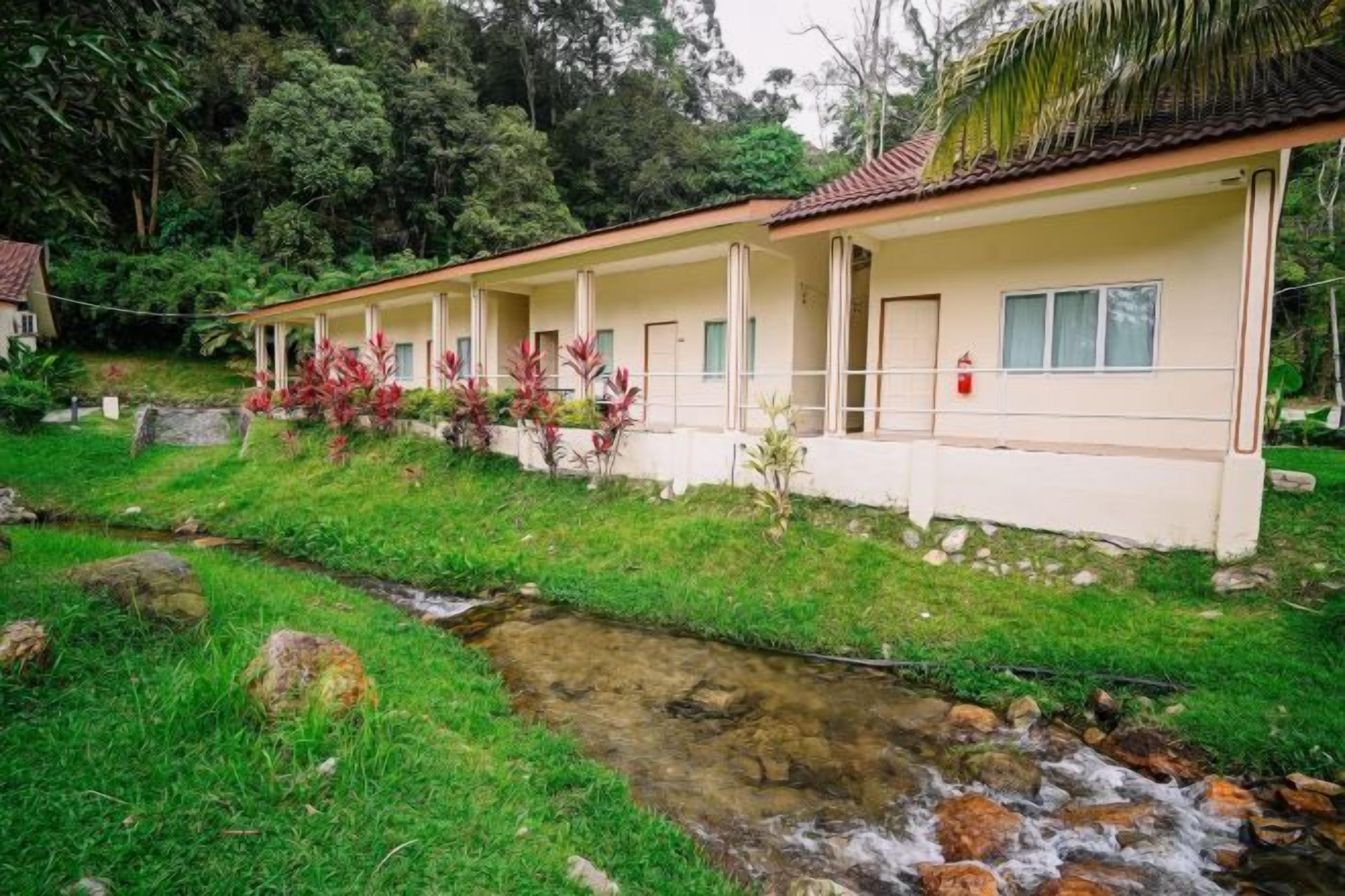 Una hilera de edificios de una sola planta con un arroyo delante.