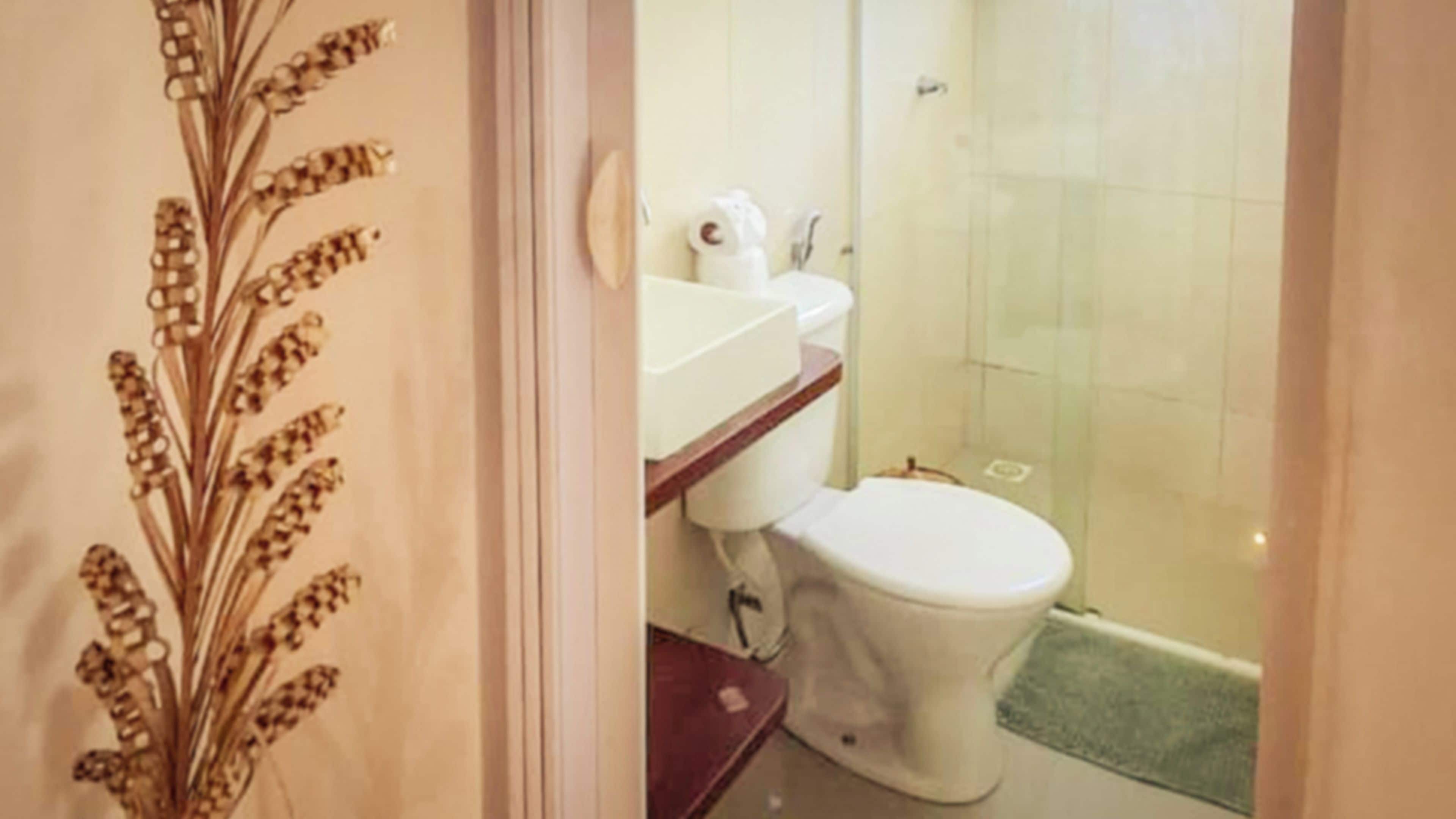 A bathroom with a toilet, sink, and shower.