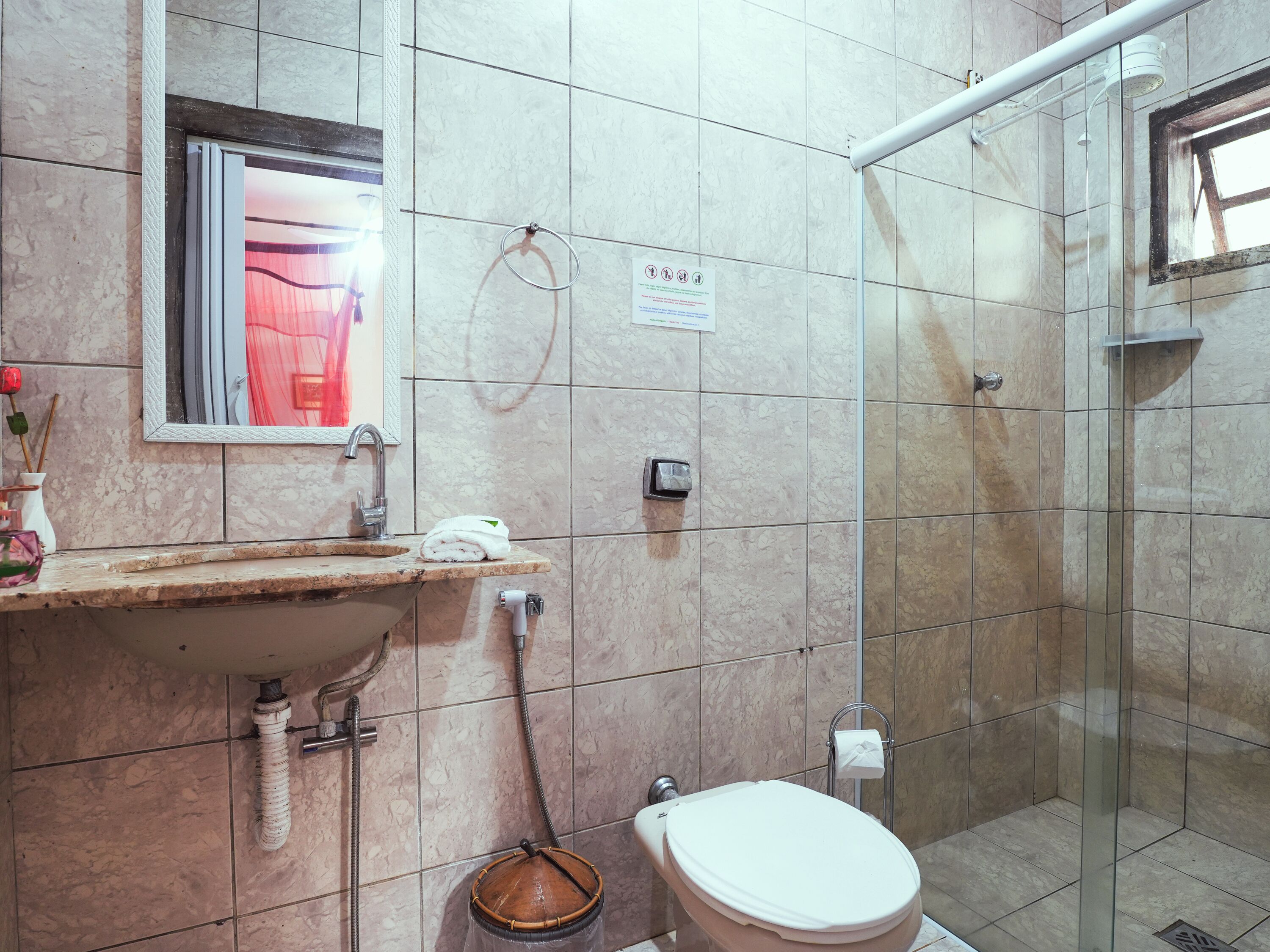 A bathroom with a sink, mirror, toilet, and shower.