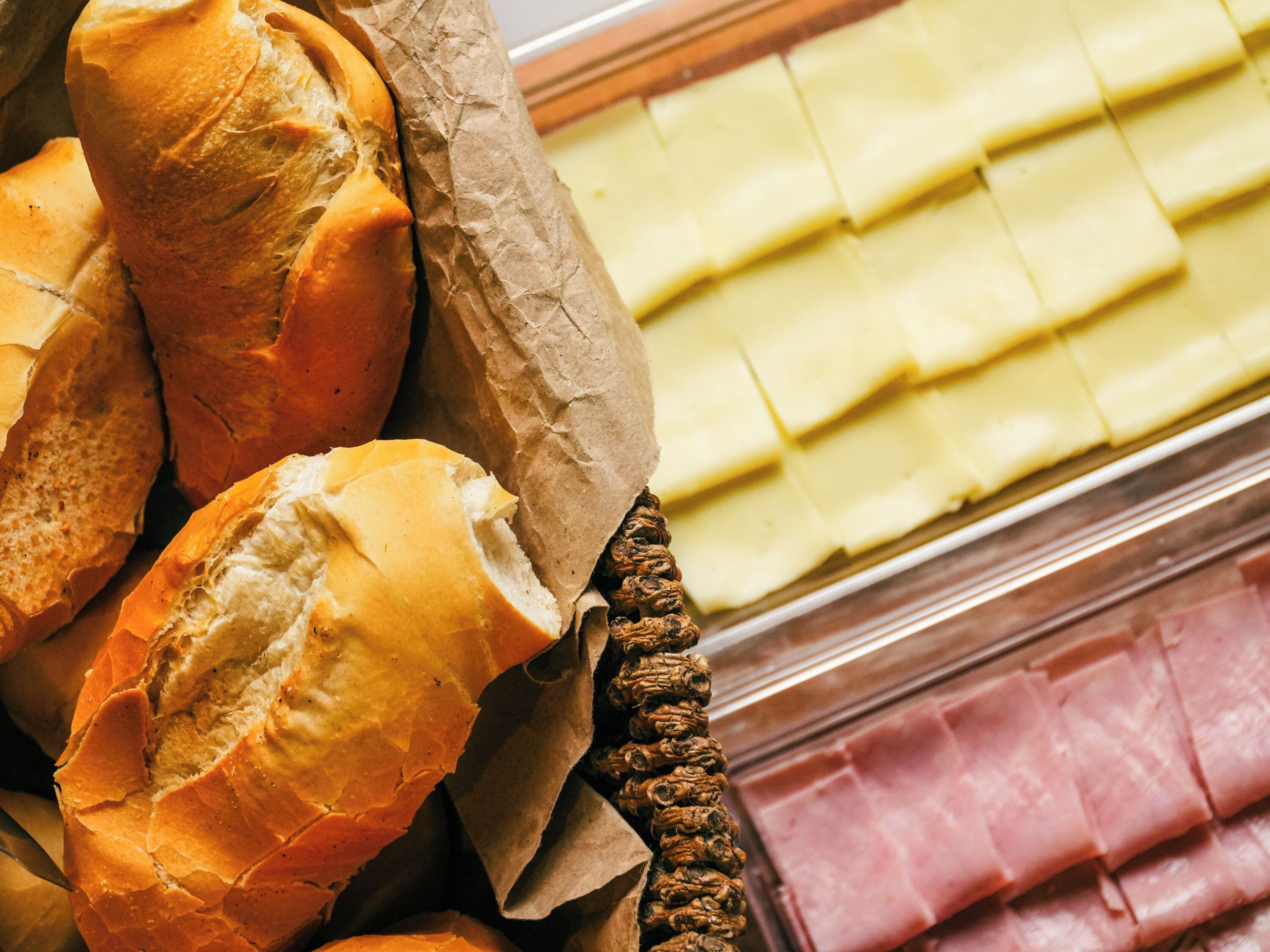 Una exposición de pan y jamón en una charcutería.
