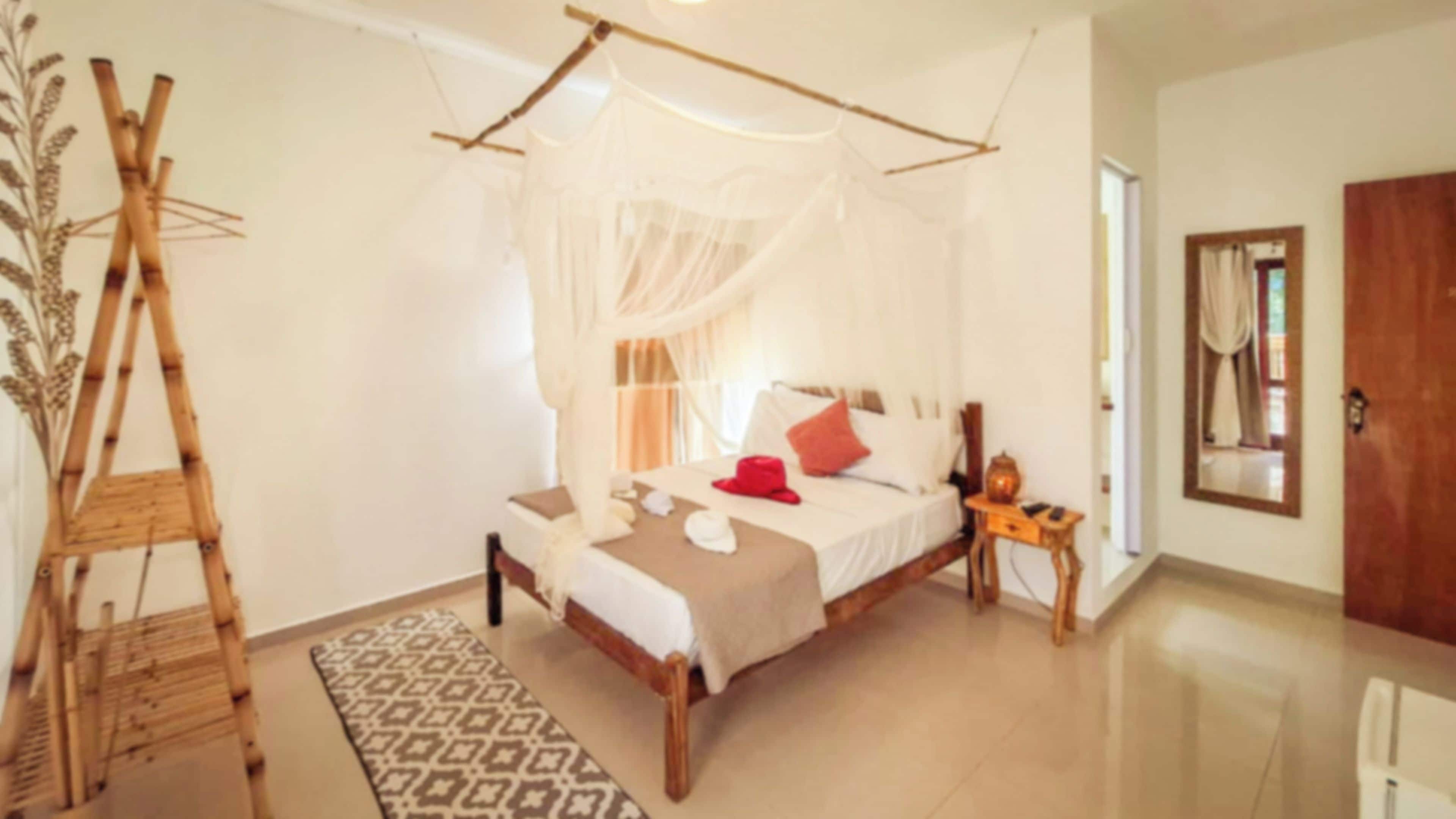 A room with a bed, a bedside table, a wooden ladder, and a patterned rug.