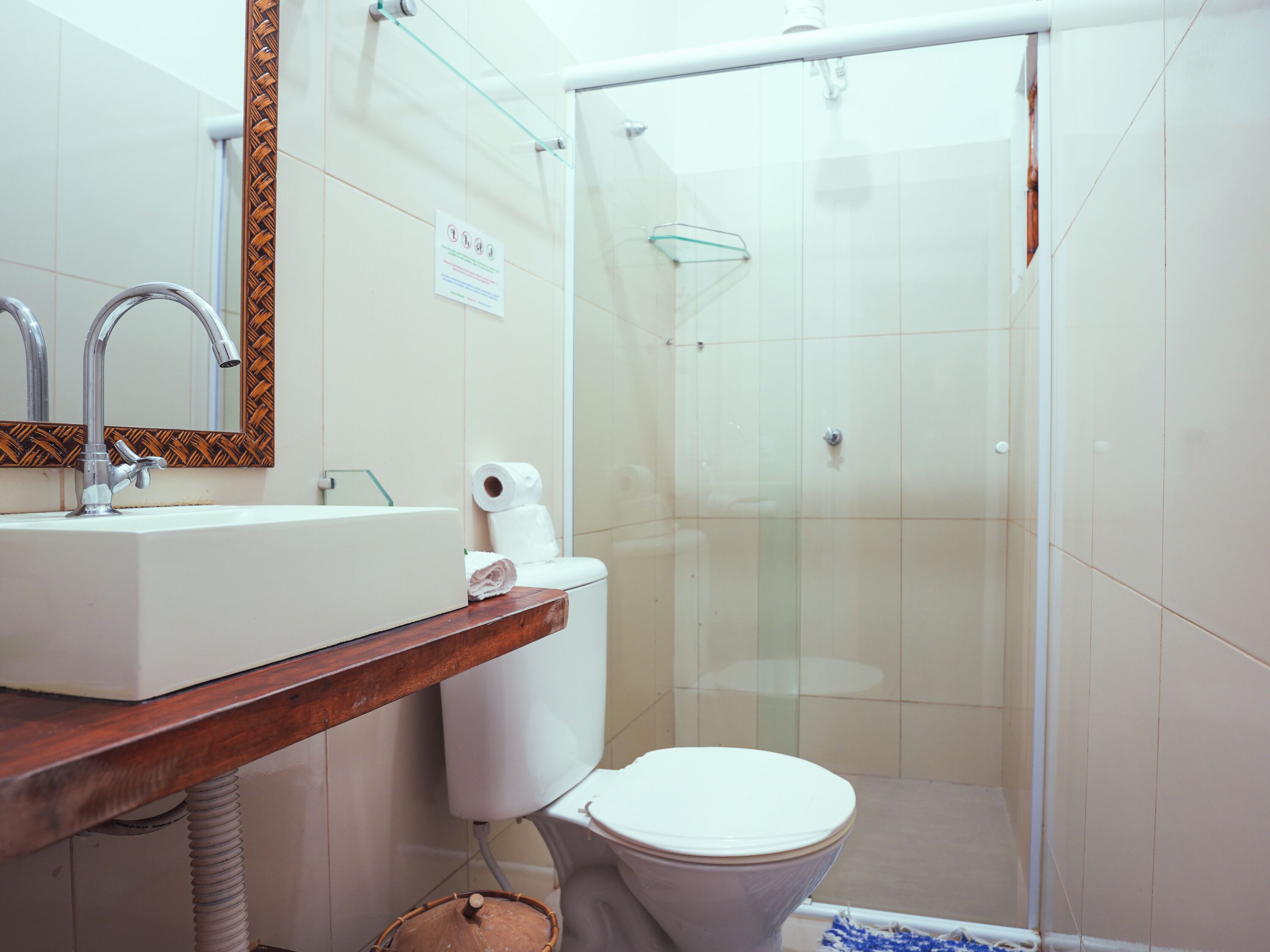 A bathroom with a white sink, mirror, and toilet.