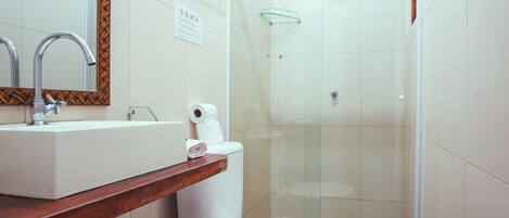 A bathroom with a white sink, mirror, and toilet.