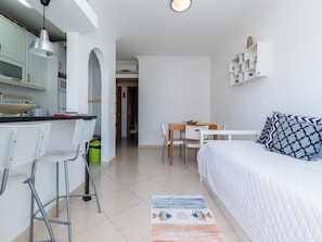 Quarto compacto e moderno com cozinha compacta, área de refeições e uma cama.