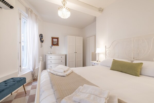 A neatly arranged bedroom with a large bed, a bedside table, a wardrobe, and a bench. - Santa Lucia Canal View by Wonderful Italy (Venice)