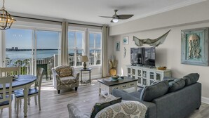 Een woonkamer met balkon, een televisie en een eethoek.