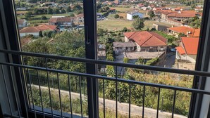 A residential area with houses, a church, and a view of distant hills. - Accommodation in house with shared pool, 10mn from Braga. Weekly rental (BRAGA)