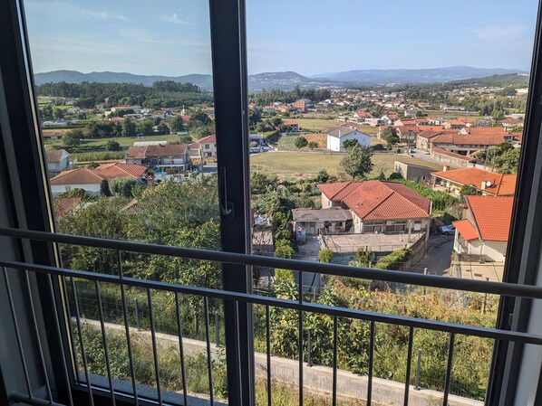 A residential area with houses, a church, and a view of distant hills.