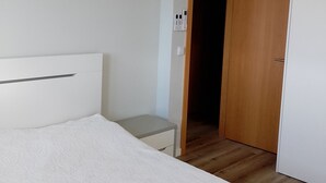A bedroom with a bed, a bedside table, a wardrobe, an air conditioning unit, and a door leading to another room. - Accommodation in house with shared pool, 10mn from Braga. Weekly rental (BRAGA)