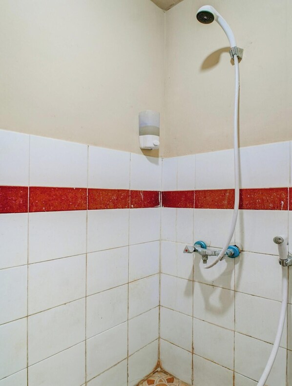 A shower with a handheld showerhead, a wall-mounted faucet, and a soap dispenser. - Collection O Serviced Apartmen Mutiara Kota (Bekasi)