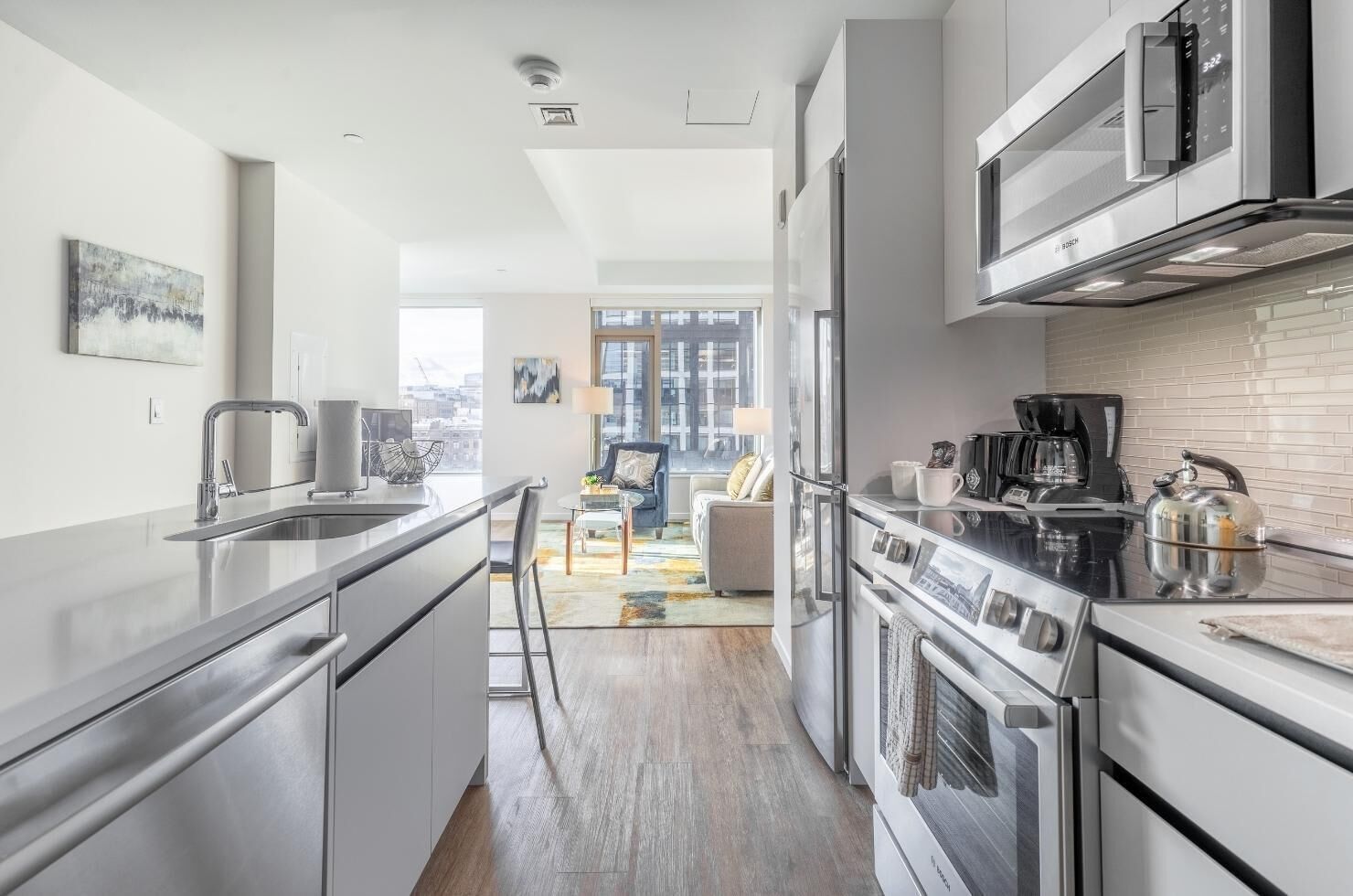 A modern kitchen with stainless steel appliances, a dining area with a view, and a cozy seating space.