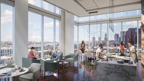 A modern office space with large windows, a central kitchen area, and multiple seating arrangements. - Stunning Apt with City Views (Boston)