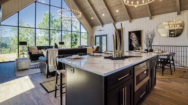 A spacious living area with a large window, a dining area with a central island, and a kitchen with modern appliances. - WALDEN'S RIDGE SPLASH! LUXURY 2 BEDROOMS! (Sevierville)