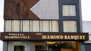 Un hôtel appelé «Hotel Diamond Villa», doté d’une façade moderne, de grandes fenêtres et d’une enseigne bien visible pour «The Diamond Banquet».
