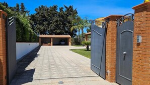 A gated driveway leading to a building with a tiled entrance and a covered carport. - Green Relax Arenella (Arenella)