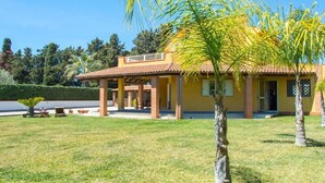 A two-story house with a tiled roof, a covered patio, and a well-maintained lawn. - Green Relax Arenella (Arenella)