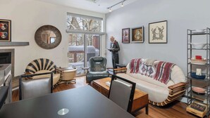 Un salon moderne comprenant un canapé, des fauteuils, une table à manger et une cheminée.