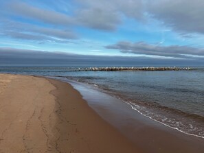 Na praia, espreguiçadeiras, toalhas de praia 